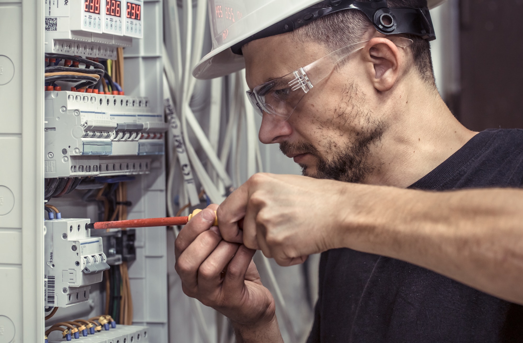 a-male-electrician-works-in-a-switchboard-with-an-electrical-connecting-cable.jpg